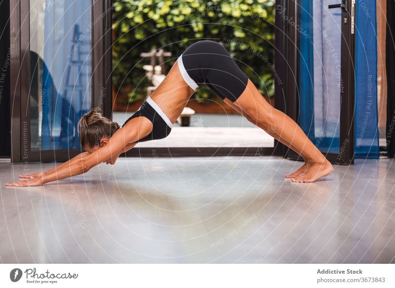 Schlanke Frau macht Yoga in Downward Facing Dog Position nach unten gerichteter Hund Asana Pose adho mukha svanasana heimwärts Gelassenheit schlank Gesundheit