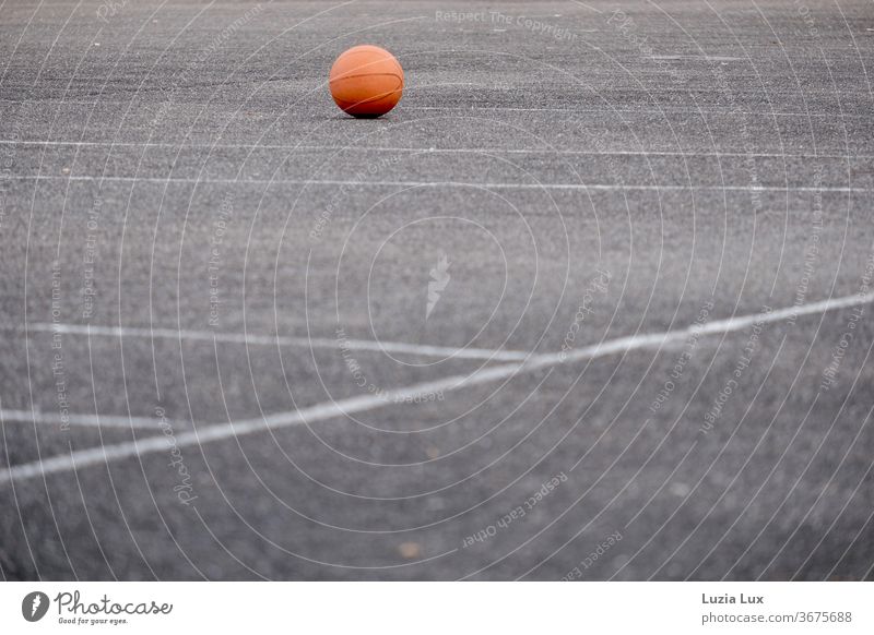 Ein vergessener Ball liegt im Abendlicht auf dem leeren Sportplatz Ballsport Spielen Freizeit & Hobby Farbfoto Außenaufnahme Menschenleer Sportstätten orange