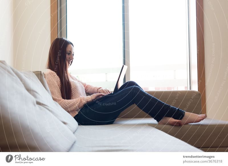 Frau auf Couch mit Laptop Liege heimwärts Sofa jung benutzend Glück Technik & Technologie Raum Sitzen schön digital lässig im Innenbereich Person modern