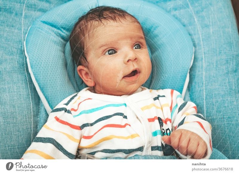 Neugieriges und glückliches neugeborenes Mädchen in der Hängematte Baby lustig Gesicht neugierig bezaubernd niedlich Junge unisex Lächeln expressiv Gefühle