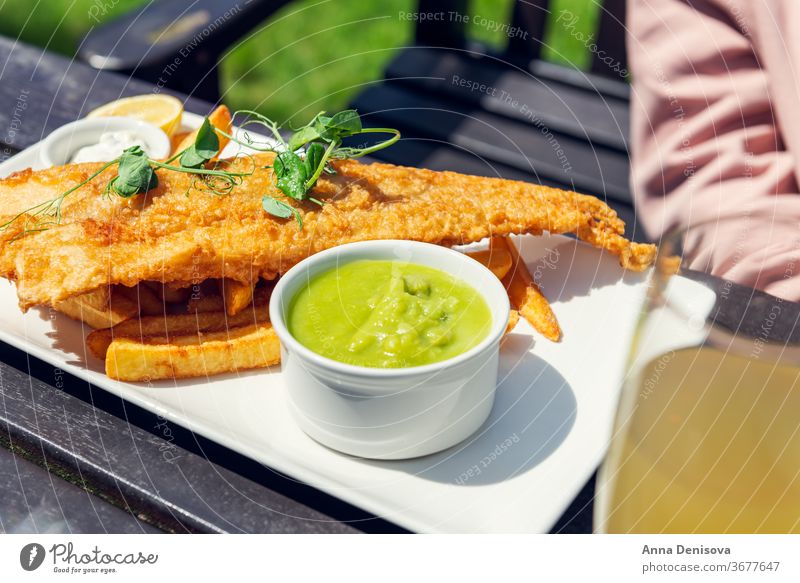 Fisch und Pommes Frites mit Erbsen Chips Lebensmittel Schellfisch Seehecht ramponiert Dorsch Englisch Knusprig Filet Abendessen Briten gebraten Mahlzeit