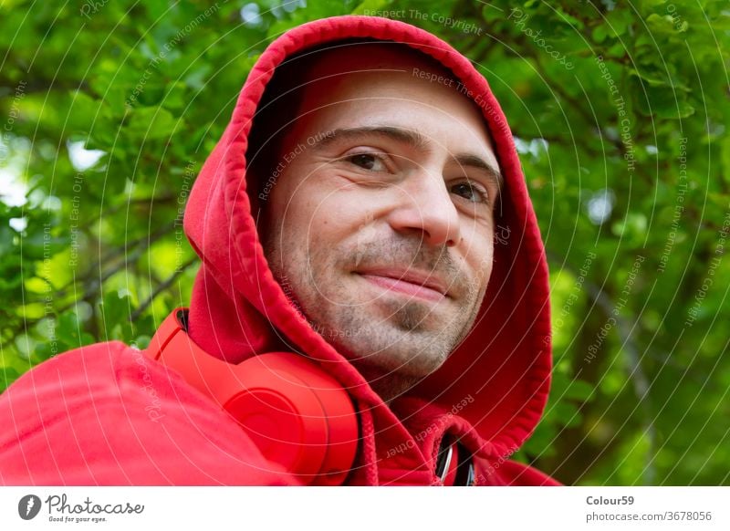 Fröhlicher junger Mann Hintergrund Kopfhörer Kapuzenpulli männlich Porträt Musik Atelier gutaussehend hören Person Erwachsener Typ Menschen attraktiv lässig