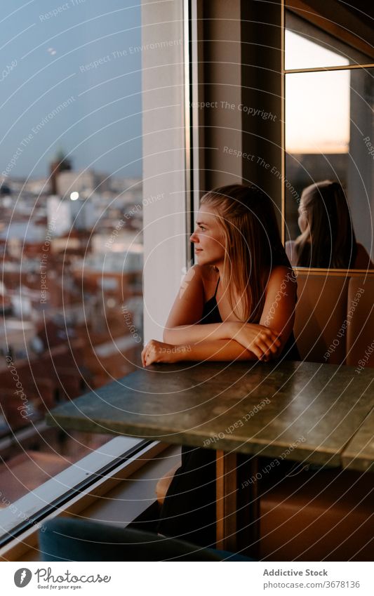 Junge Frau genießt das Stadtbild vom Café aus Dachterrasse Großstadt Fenster Abend Madrid Sonnenuntergang gemütlich urban Spanien Glaswand Komfort