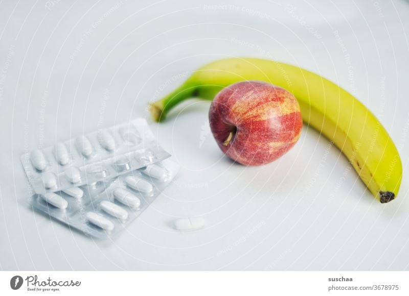 gesunde ernährung vs. nahrungsergänzungsmittel .. apfel, banane und tabletten Apfel Banane Tabletten Frucht Gesundheit Lebensmittel Vegetarische Ernährung