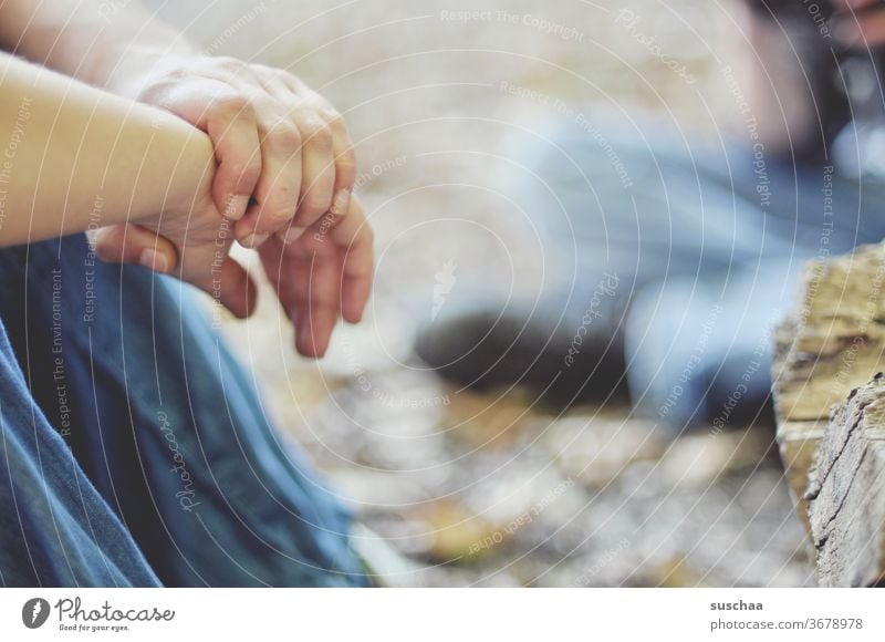 hände einer auf dem boden im freien sitzenden person Hand Hände Finger festhalten Person Frau Boden auf dem Boden im Freien draußen ausruhen chillen