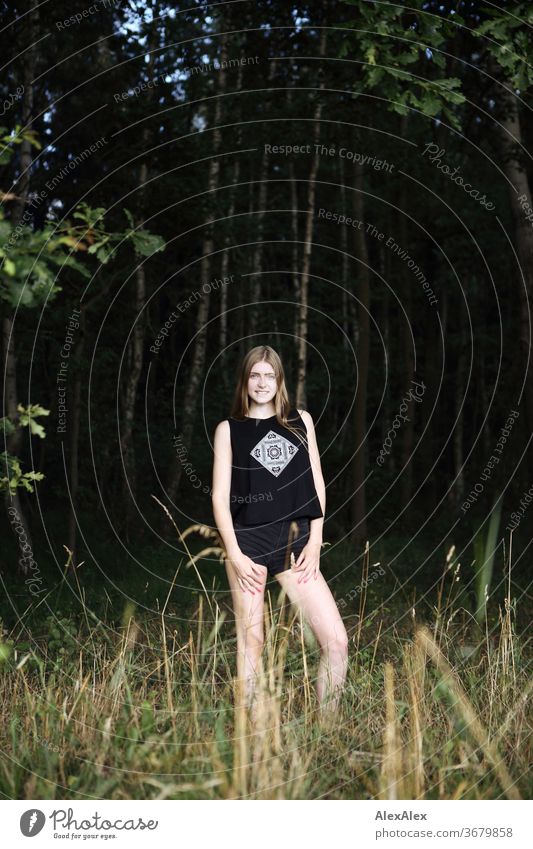 Portrait einer jungen Frau in der Natur vor einem Wald Reinheit Glück Schönes Wetter Ausflug Erwartung Sonnenlicht Nahaufnahme Tag Blick in die Kamera Farbfoto