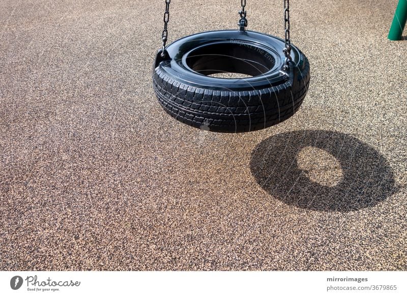 schwarze Kette Reifenschaukel auf einem Kinderspielplatz keine Menschen Aktivität Hintergrund Schwarze Kette Reifenschaukel Ketten Kindheit Kinder schaukeln