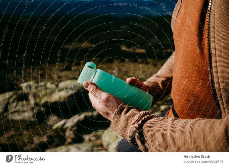 Anonymer männlicher Wanderer mit Wasserflasche in den Bergen Mann Berge u. Gebirge ruhen Ausflug Himmel Flasche puerto de la morcuera Durst Spanien Hydrat Stein