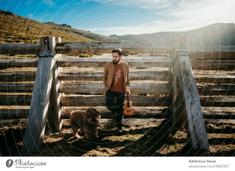 Männlicher Reisender mit Hund rastet in der Nähe von Zaun Mann ruhen Berge u. Gebirge fettarm sonnig tagsüber puerto de la morcuera Spanien männlich Landschaft