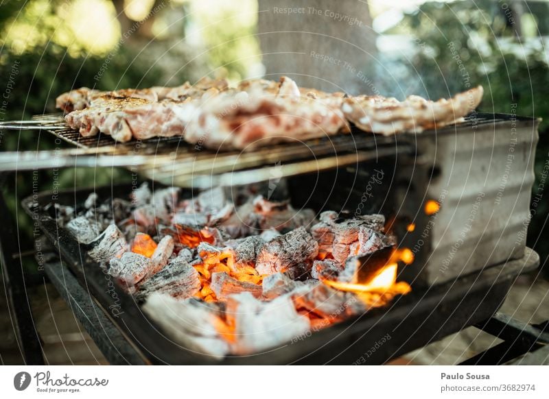 Grillen von Fleisch auf dem Grill Barbecue Grillrost gegrilltes Fleisch Ernährung Farbfoto Außenaufnahme Grillsaison Grillkohle Sommer heiß Lebensmittel lecker