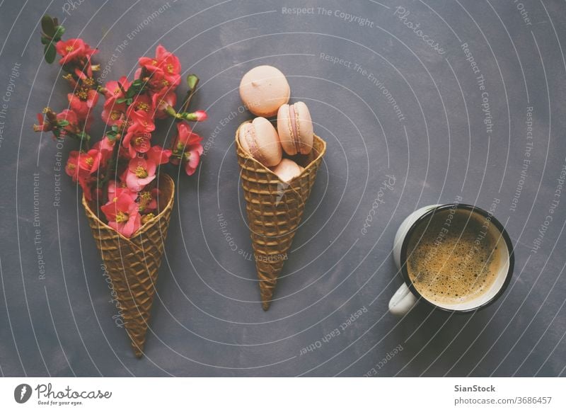 Kaffee, Makronen und Blumen in Eistüte auf Zementhintergrund Morgen Top Macaron Ansicht Tisch Tasse weiß Hintergrund legen flach Schreibtisch rosa Frühstück