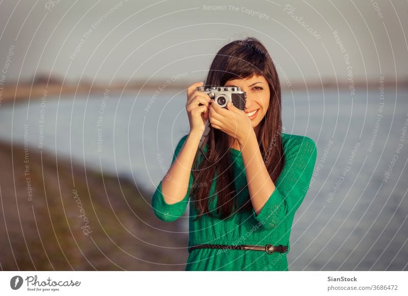 Vintage-Foto, brünettes Mädchen mit Retro-Kamera Strand Fotokamera altehrwürdig retro Meer Urlaub Menschen Sommer reisen blau Fotograf Mode Lifestyle Feiertag