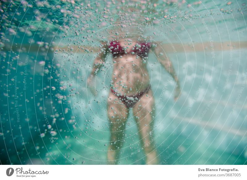 junge frau taucht schwimmend in einem schwimmbad. sommer und spaßiger lebensstil. selektiver fokus auf blubberblasen. Frau unter Wasser Schwimmsport Sommer