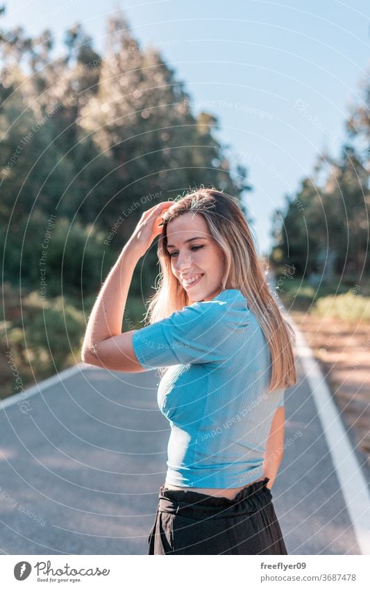 Porträt einer jungen und attraktiven kaukasischen Frau in der Nähe eines Waldes 20s Straße Außenseite im Freien Lifestyle Kaukasier blond Entsättigt retro