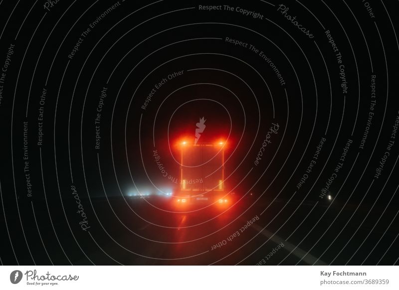 Rücklicht eines Lastwagens bei Nacht und Regen Asphalt Autobahn Unschärfe verschwommen PKW Autos gefährlich dunkel Laufwerk fahren Fernstraße beleuchtet Reise