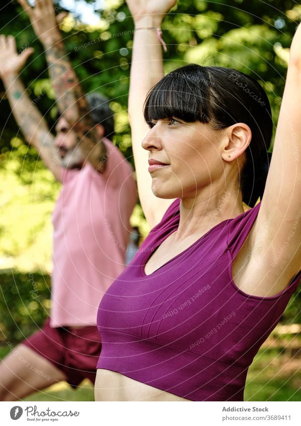 Ruhiges Paar übt Yoga in Halbmond-Pose zusammen Halbmondvariation Ausfallschritt hohe Longe Zusammensein Park Barfuß sonnig Training Partnerschaft ruhig