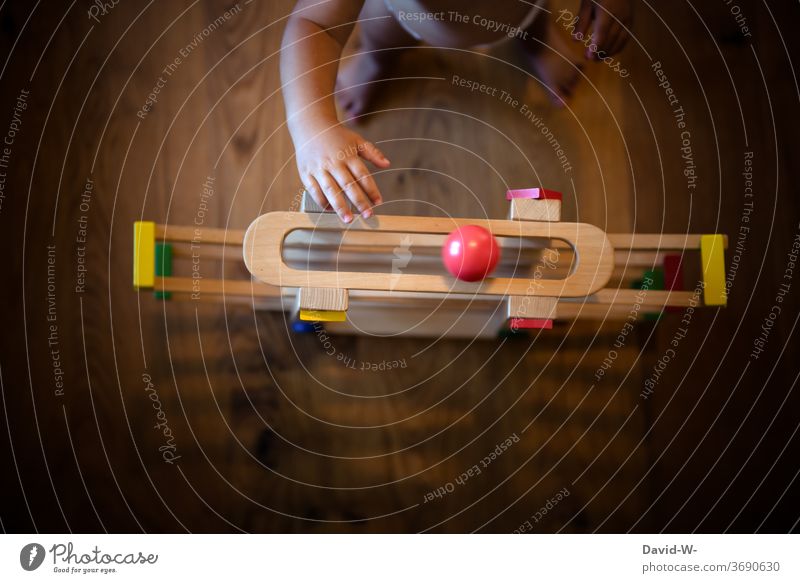 Kind spielt mit seinem Spielzeug spielen Kinderzimmer Kleinkind stehen benutzen greifen jung niedlich anonym tasten Finger Hände Kugel Spielen Kindheit Freude