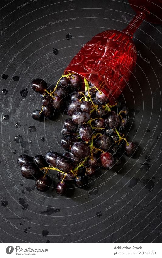 Weinglas und rote Trauben auf dem Tisch verschütten Frucht Haufen Glas reif frisch natürlich Weingut Kelch Bestandteil Ernte organisch Lebensmittel lecker