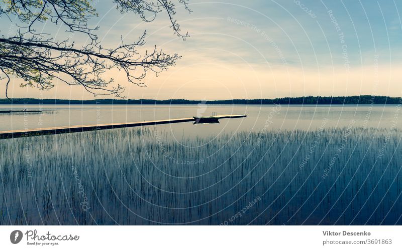 Boot an der Mole auf dem See im Frühling Baum Wasser Sommer Lettland Natur Sonne Windstille Landschaft Pier Himmel im Freien Fluss Szene reisen Europa hölzern