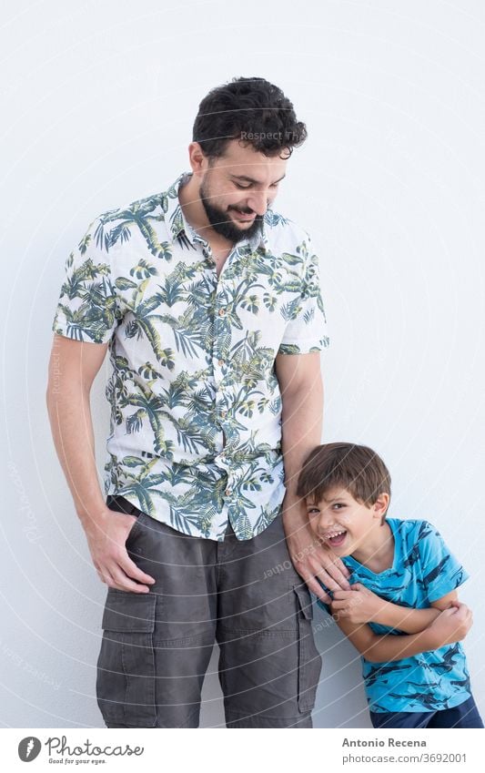 Sie und ihre Tochter spielen und posieren auf einer weißen Wand in ihrem Hinterhof. Mann Lebensstile Vater Sohn Vatertag Umarmung vereinzelt weißer Hintergrund