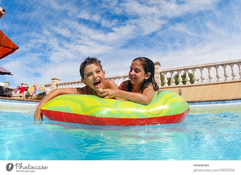 Zwei lustige Kinder im Pool auf einer Luftmatratze Aktivität blau sorgenfrei Kindheit niedlich genießen Familie Schwimmer Frische Freund Freunde Freundschaft