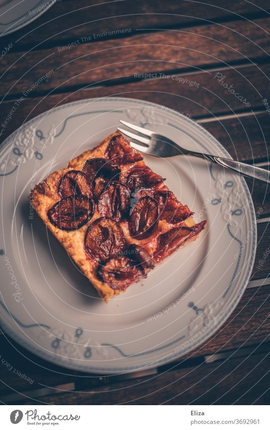 Ein Stück Pflaumen-dachi auf einem Teller bei der Oma Pflaumen-Dackel Pflaumenkuchen Kuchen lecker Tisch verschnörkelt altehrwürdig altmodisch Backwaren