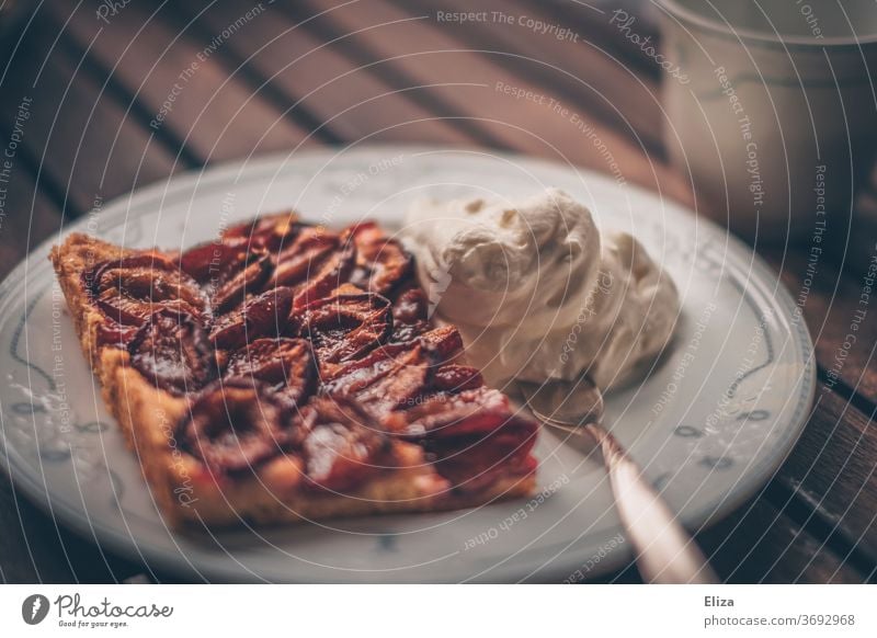 Zwetschgendatschi mit Sahne auf einem Teller Kuchen Backwaren Zwetschgenkuchen lecker Herbst Teigwaren süß Kaffeetrinken Kuchen essen