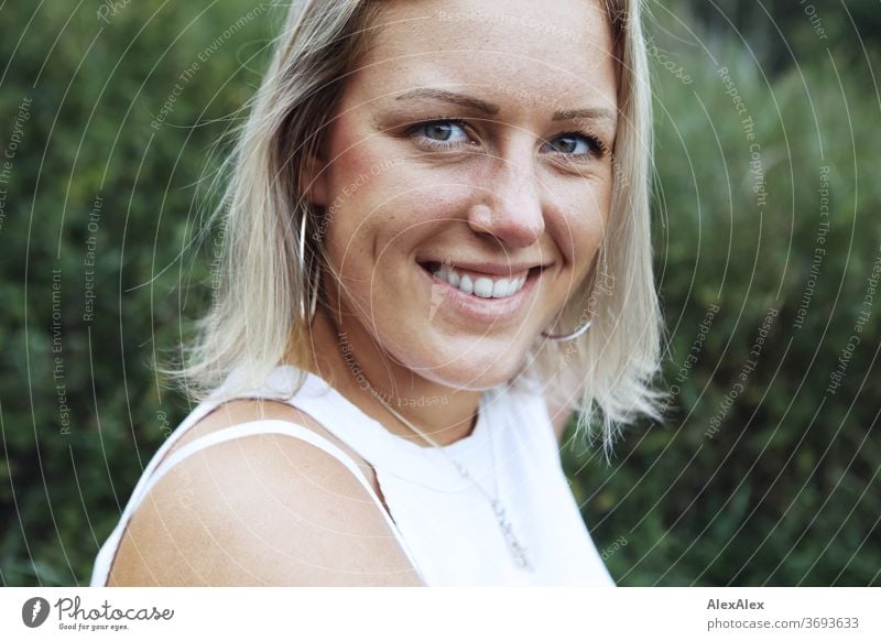 Portrait einer lächelnden, jungen Frau in der Natur junge Frau blond Lächeln Schmuck schön langhaarig Landschaft gebräunt selbstbewußt Sommer natürlich weiblich