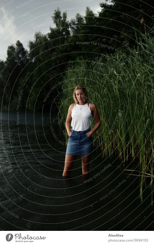 Portrait einer jungen Frau in einem See vor Schilf junge Frau blond Lächeln Schmuck schön langhaarig Landschaft gebräunt selbstbewußt Sommer natürlich weiblich