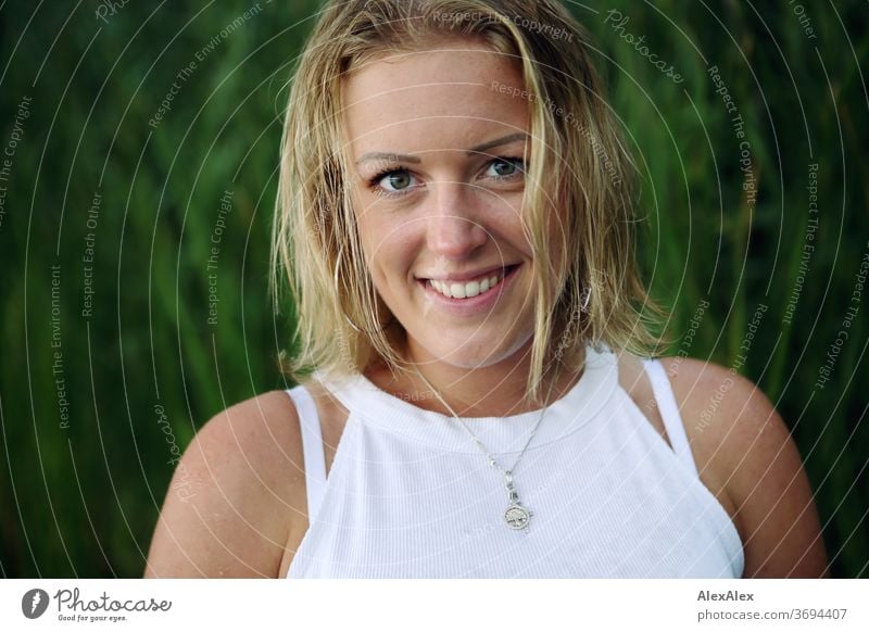 Portrait einer lächelnden, jungen Frau in der Natur junge Frau blond Lächeln Schmuck schön langhaarig Landschaft gebräunt selbstbewußt Sommer natürlich weiblich