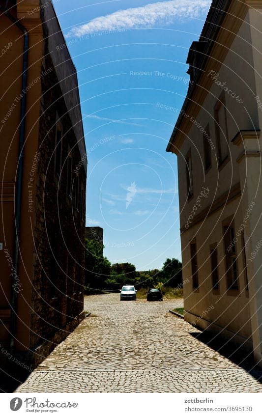 Häuserschlucht in Stassfurt straße platz parkplatz haus wohnhaus wohngebiet wohnen mehrfamilienhaus auto zwei paar sommer sonne stadt kleinstadt stassfurt