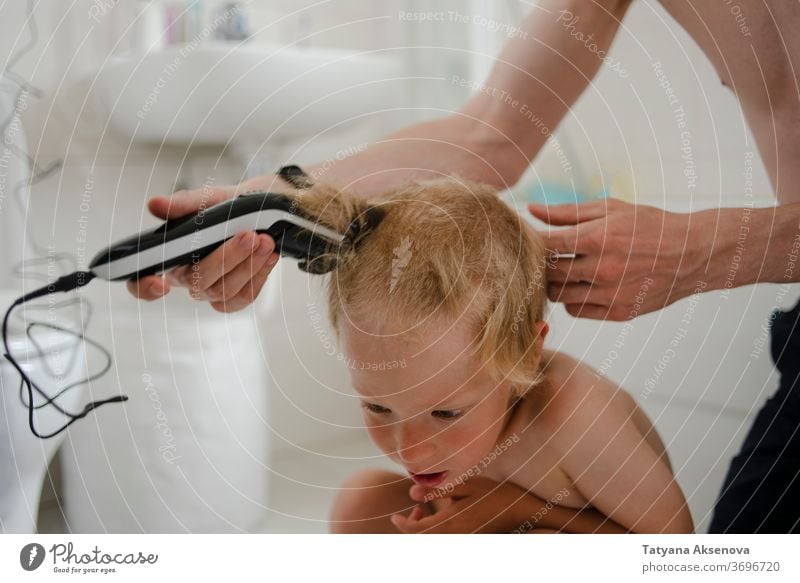 Vater schneidet dem Sohn zu Hause die Haare Behaarung Haarschnitt heimwärts Frisur Kind Pflege Maschine Bad Familie Hand geschnitten Friseur Mann Trimmer