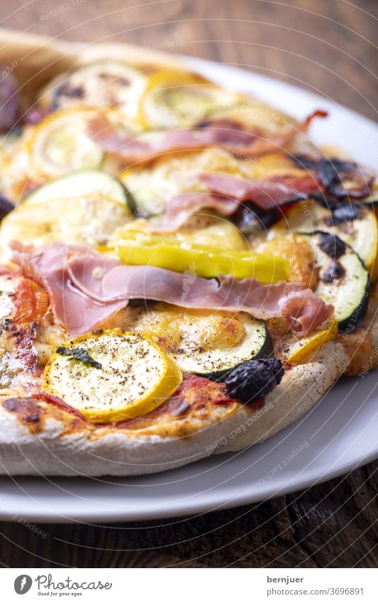 Pizza mit Zucchini Teller Schinken Käse Holz Lebensmittel Mahlzeit Italienisch zucchinipizza gemüsepizza gebacken tisch frisch diät gesund essen abendessen