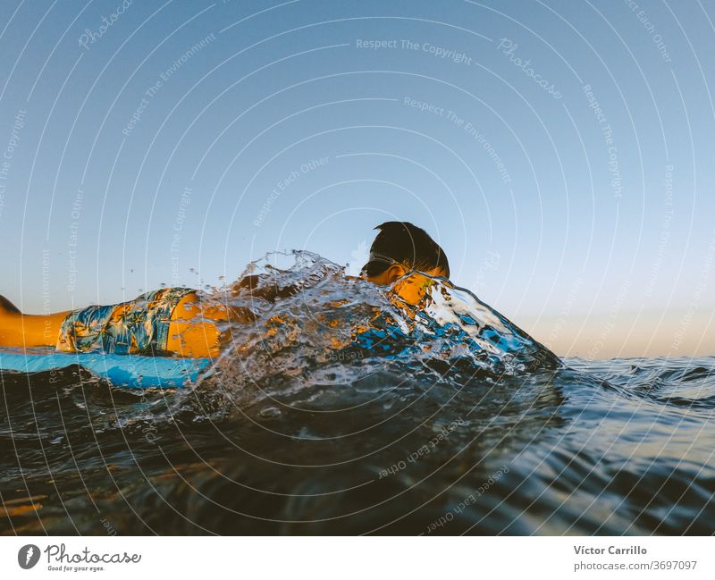 Ein kleiner Junge lernt an einem sonnigen Sommertag draußen an der Küste im Bodyboard bodyboarder Kind Feiertag Urlaub Freizeit Ufer Lifestyle Surfbrett