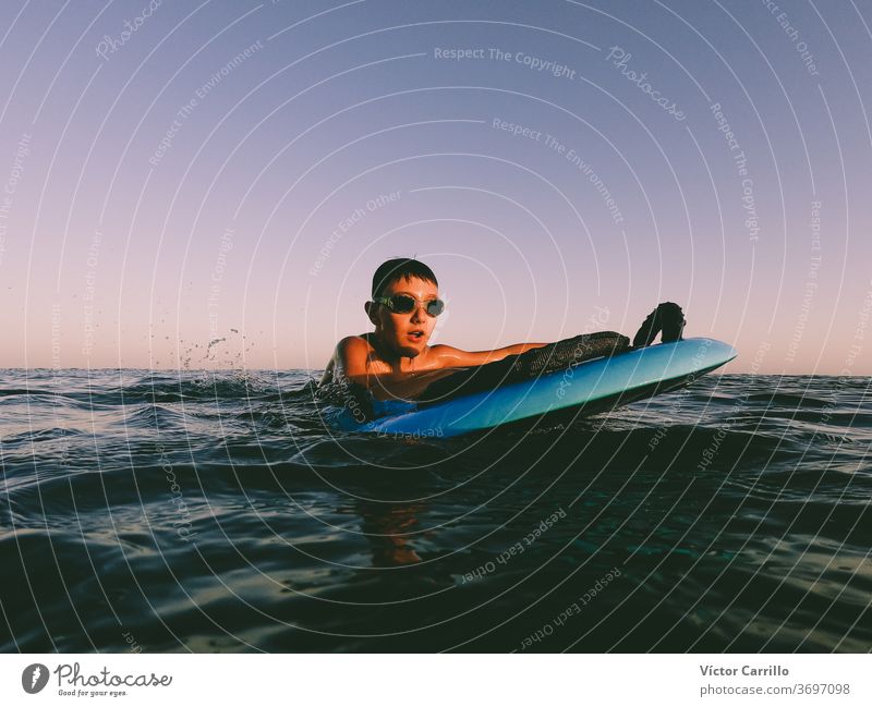 Ein kleiner Junge lernt an einem sonnigen Sommertag draußen an der Küste im Bodyboard bodyboarder Kind Feiertag Urlaub Freizeit Ufer Lifestyle Surfbrett