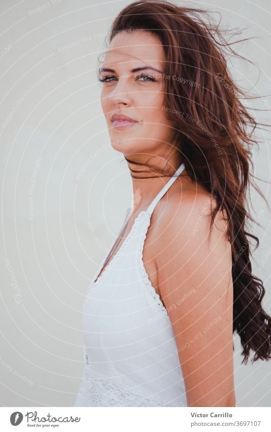 Eine elegante Frau in einem weißen Kleid in einem mediterranen Landort im Sommer in Südspanien Kapuzen-Portrait Frauen Stimmung Kaukasier Glück genießend gut