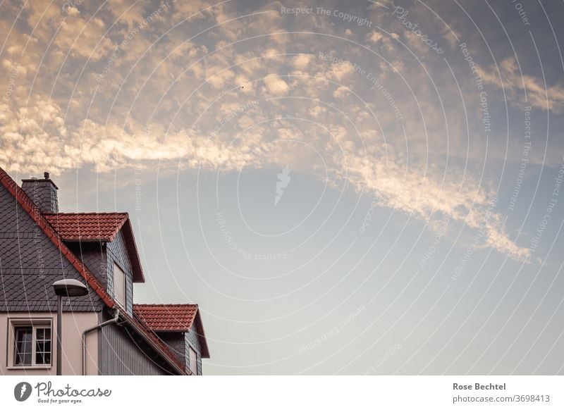 Leuchtende Abendwolken über Giebeldach Wolken Abendhimmel Haus Dach Fenster Architektur Fassade Gebäude Himmel Außenaufnahme Farbfoto Menschenleer Bauwerk