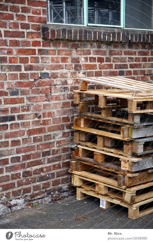 Ein Stapel Einwegpaletten steht vor einem Gebäude Paletten Palettenstapel Mauer Holz Fenster Arbeitsplatz Güterverkehr & Logistik Lagerhalle Spedition Versand