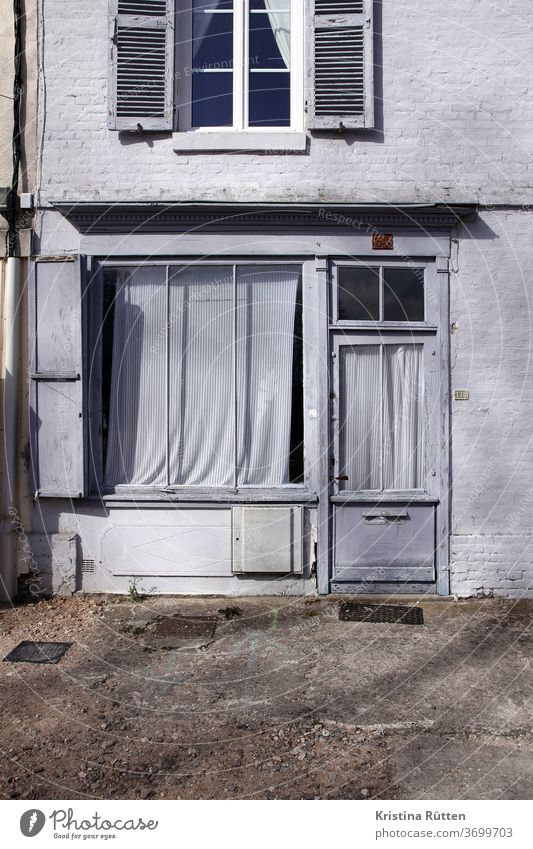 fassade in hellblau haus tür fenster fensterladen vorhang eingang schaufenster architektur fensterfront fensterscheibe hübsch pastell gestreift gebäude geschäft