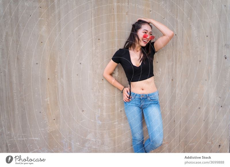 Frau in trendiger Kleidung in der Stadt Stil urban Outfit Lächeln Freude lässig trendy Mode Großstadt ethnisch asiatisch Sonnenbrille Sommer