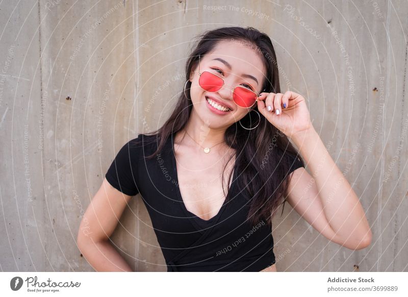 Frau in trendiger Kleidung in der Stadt Stil urban Outfit Lächeln Freude lässig trendy Mode Großstadt ethnisch asiatisch Sonnenbrille Sommer