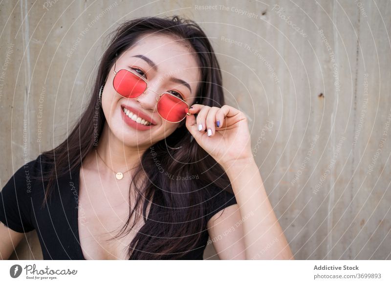 Frau in trendiger Kleidung in der Stadt Stil urban Outfit Lächeln Freude lässig trendy Mode Großstadt ethnisch asiatisch Sonnenbrille Sommer