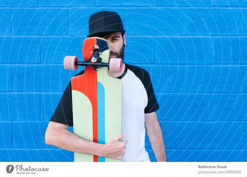 Lächelnder männlicher Skater auf der Straße Longboard Mann Hipster Sommer urban jung Großstadt heiter schlendern trendy Stadt sich[Akk] entspannen positiv