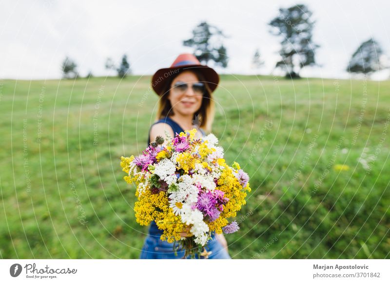 Junge Frau hält Blumenstrauss auf dem Feld Erwachsener schön Schönheit Blumenstrauß Haufen sorgenfrei lässig Charme farbenfroh Land niedlich Umwelt modisch