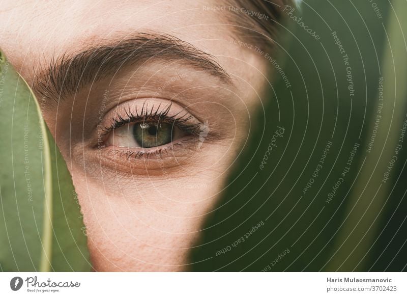 Frau Grüne Augen in Nahaufnahme mit Blatt bedeckt in der Natur Konzept von Schönheit und Natur attraktiv schön Kaukasier abschließen Korona Korona-Konzept