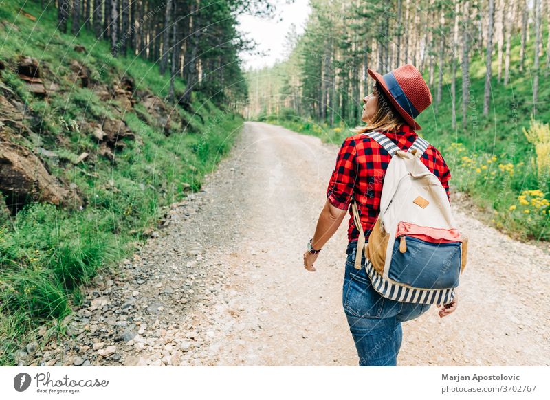 Junge Naturforscherin wandert auf unbefestigter Bergstraße aktiv Abenteuer allein Rucksack Schmutz Fundstück genießen erkunden Entdecker Frau Wald frei Freiheit