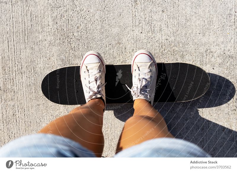 Crop Skaterin in der Stadt Skateboard Turnschuh Schlittschuh Frau Großstadt Skateplatz sonnig Sommer tausendjährig unterhalten Shorts Asphalt Straße