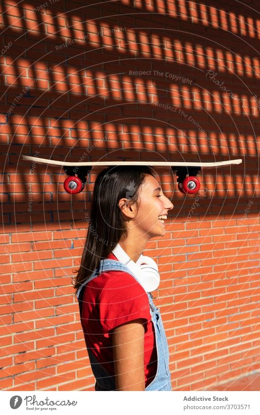 Fröhliche Frau mit Skateboard in der Stadt tausendjährig Spaß haben Gleichgewicht Skater heiter Witz Lachen lustig Großstadt Ausgeglichenheit urban Generation