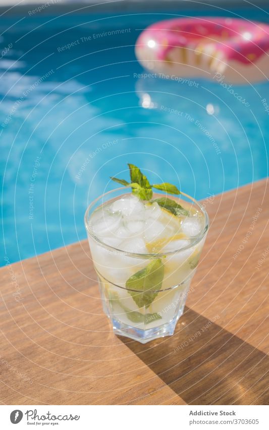 Glas Mojito-Cocktail am Schwimmbad trinken Pool Alkohol Eis Zitrone Minze kalt Getränk Zitrusfrüchte Erfrischung Frucht cool geschmackvoll lecker Feinschmecker