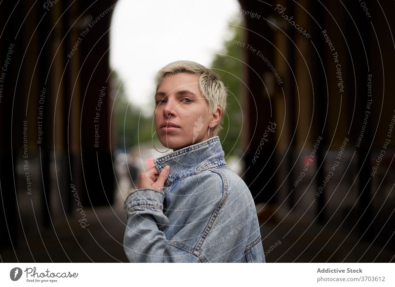 Seriöse stilvolle Frau in der Stadt Model Jeansstoff Jacke Großstadt Straße Windstille ernst Stil trendy gewölbt Durchgang lässig besinnlich Outfit nachdenklich